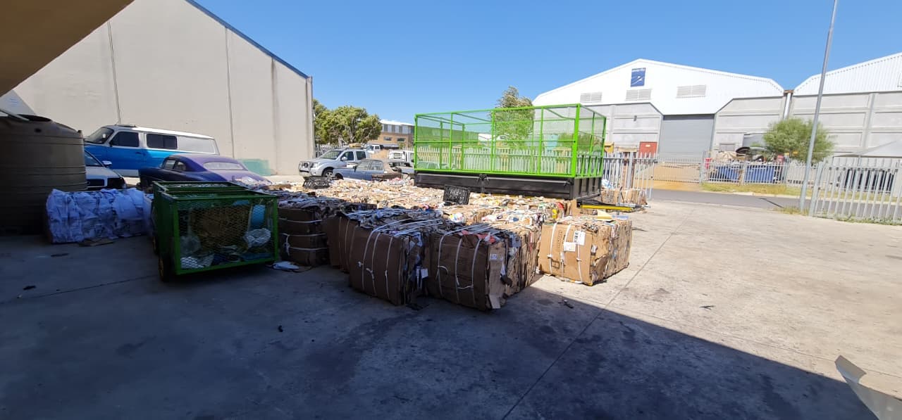 Rows of baled cardboard and green cage trailers in the WasteGo Green yard ready for dispatch