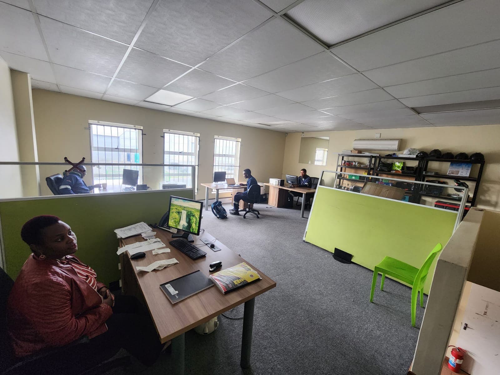 Open-plan WasteGo Green operations office with staff at desks and green accent panels